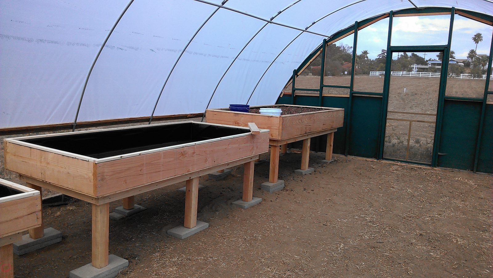 The completed run of grow tables inside the hoop house.