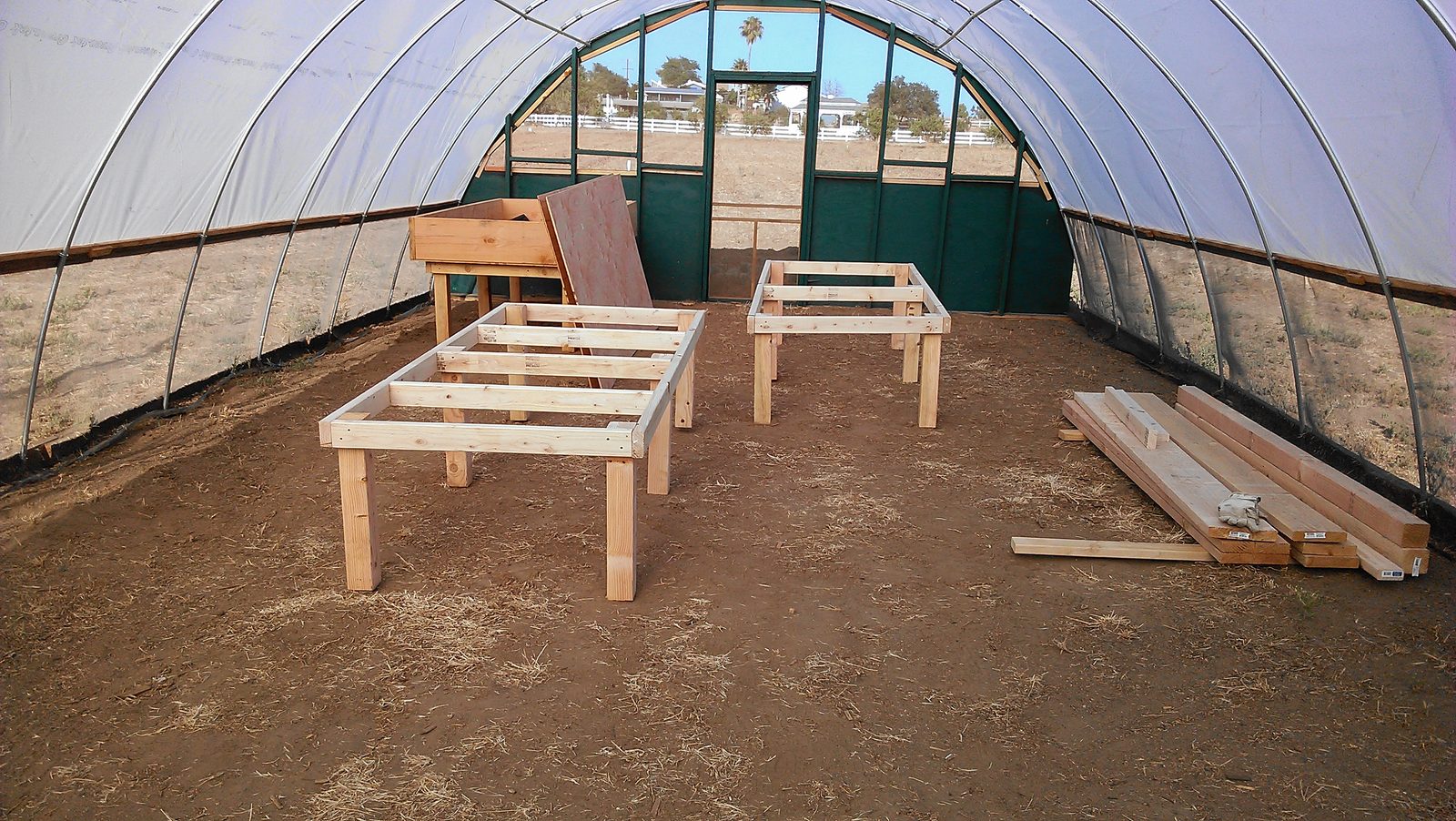 Timber grow table frames standing inside the hoop house before lining.