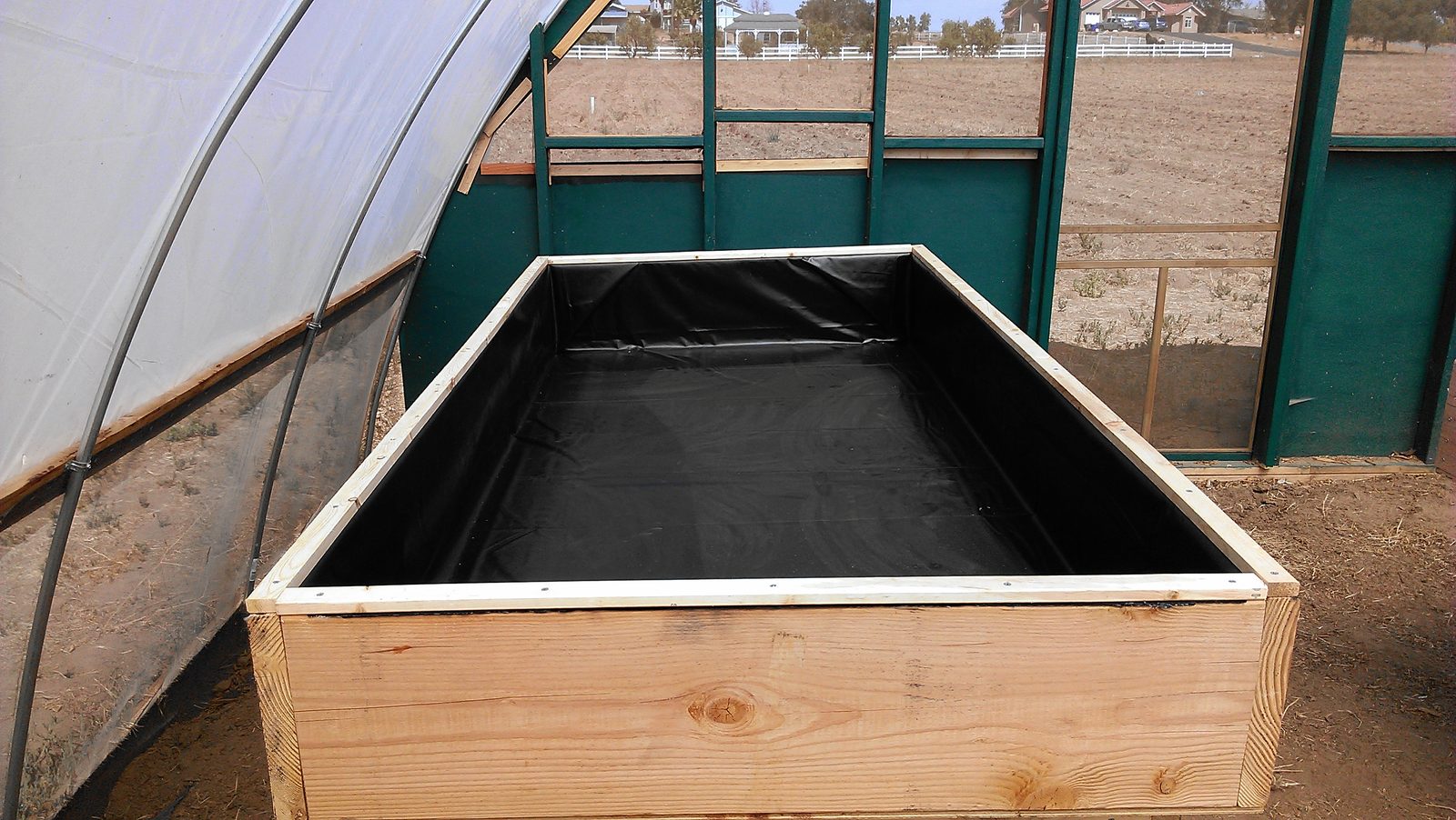 A grow table lined with black pond liner, ready to hold water.