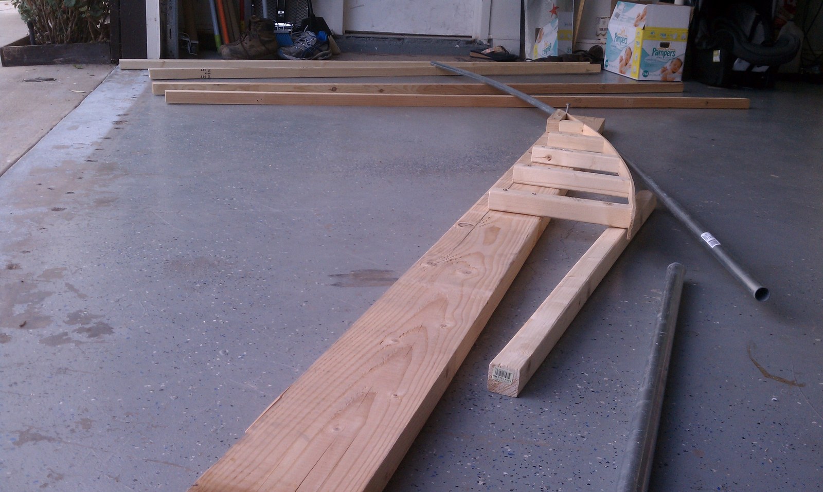 A wooden bending jig with a length of conduit curved around it.