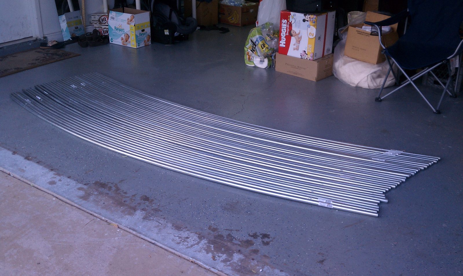 A dozen identical bent conduit ribs fanned out across a concrete floor.