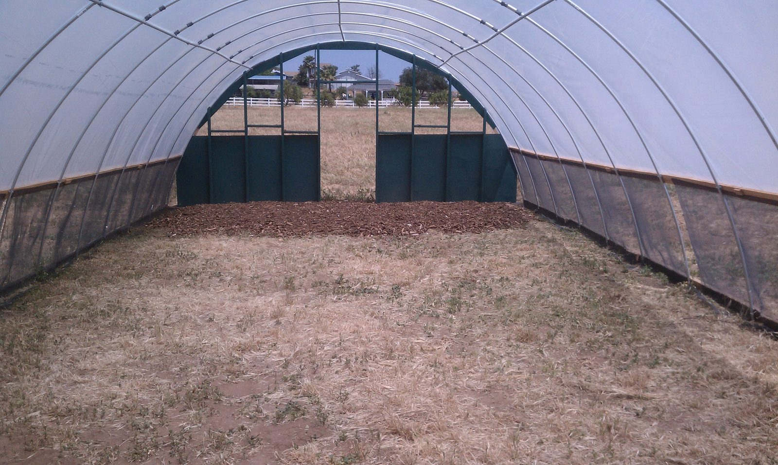 Interior view down the length of the finished hoop house toward the far door.